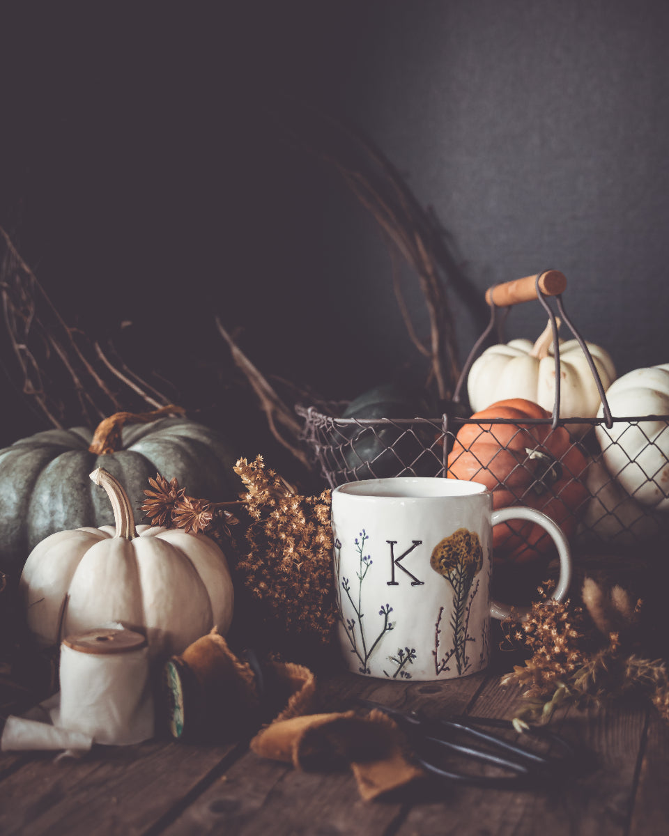 Moody still life with small pumpkins and a mug