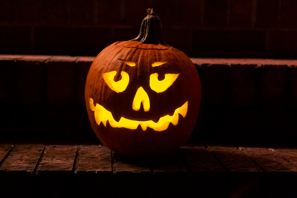 Glowing jack-o'-lantern on brick at night
